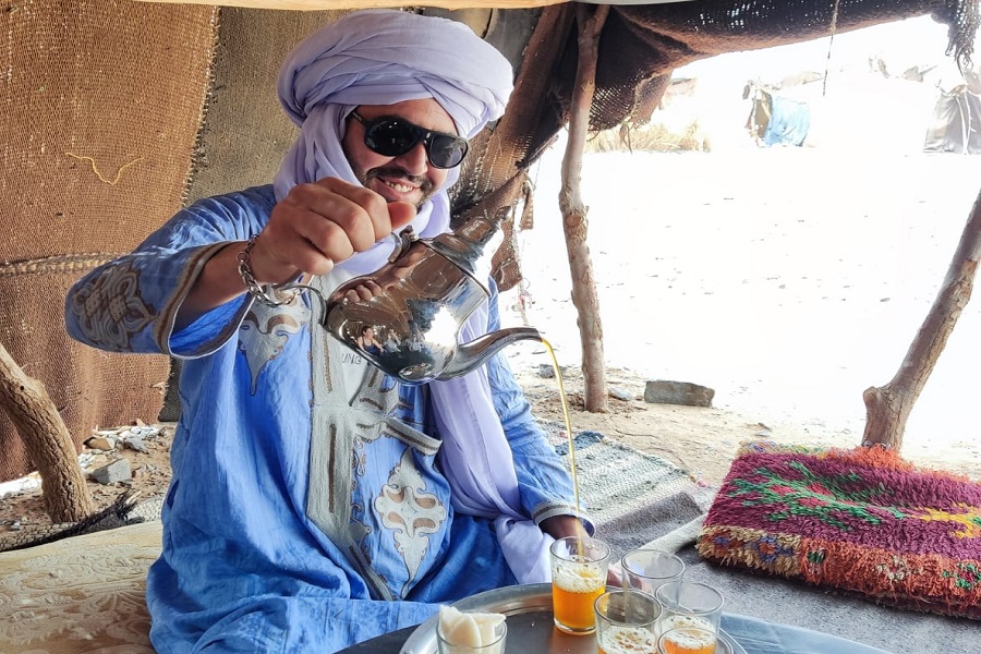 Anfitrión sirviendo té de menta en una tienda bereber del desierto